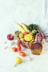 Vegetables, fruits and greens in a wicker basket, on a wooden table, harvest season, organic natural food, healthy food, home cooking