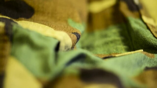 Camera focus  going through military clothes than fades to blur macro background footage.