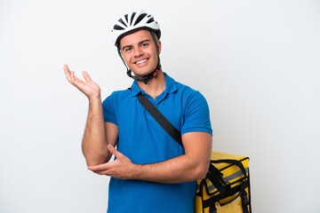 Young caucasian man with thermal backpack isolated on white background extending hands to the side for inviting to come