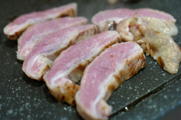 grill pork cut into bite-size pieces on an open fire.