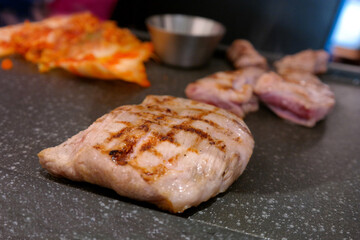 grilling large pieces of pork on an open fire.