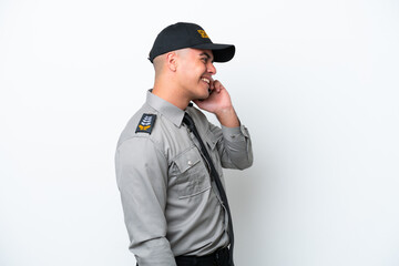 Young caucasian security man isolated on white background keeping a conversation with the mobile phone with someone