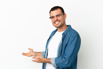 Brazilian man over isolated white background extending hands to the side for inviting to come