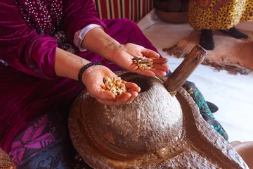 Crédence de cuisine en verre imprimé Maroc Women making argan oil, Morocco. Holding seeds with her hands. Real people doing real things. Africa