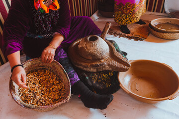 Women making argan oil, Morocco. Holding seeds with her hands. Real people doing real things. Africa - obrazy, fototapety, plakaty