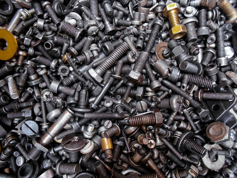 Pile of random screws. metal nut bolts industrial hardware tools closeup picture