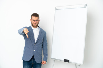 Young business woman giving a presentation on white board isolated on white background showing thumb down with negative expression