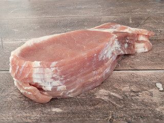 Slices of raw back bacon on a wooden table