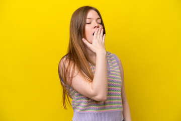 Young caucasian woman isolated on yellow background yawning and covering wide open mouth with hand