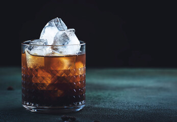 Trendy alcoholic cocktail drink with vodka, coffee liqueur, cream and ice, gray background, bar...