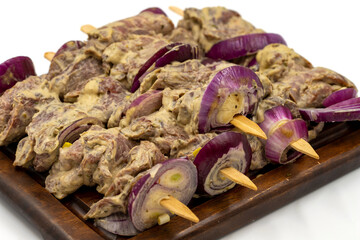 Saslik kebab isolated on white background. Raw saslik kebab on wooden presentation board. close up