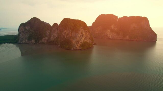 Aerial view over the coast, mountains and beaches during beautiful sunsets. Paradise island of &ldquo;Underwater Wedding Beach&rdquo; Trang, Thailand. 4k drone footage
