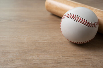 Close up baseball and baseball bat on wooden table background, sport concept