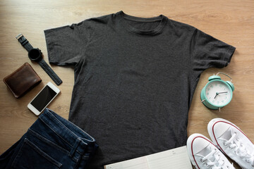 Mockup of a gray t-shirt blank shirt template with accessories on the wooden table background, lifestyle and travel concept - obrazy, fototapety, plakaty