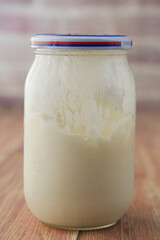 close up of Mayonnaise in container on table .