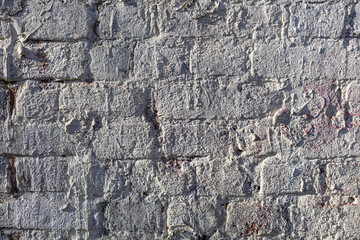 fragment of an old brick wall covered with whitewash