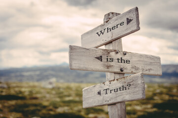 where is the truth text quote written in wooden signpost outdoors in nature. Moody theme feeling.