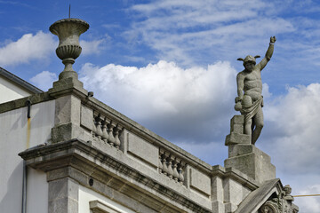 statue and coat of arms on the roof of a patriarchal house in Porto, Portugal