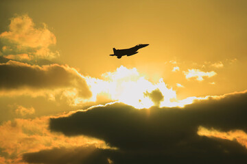 Fototapeta na wymiar silhouette of airplane flying over sunset