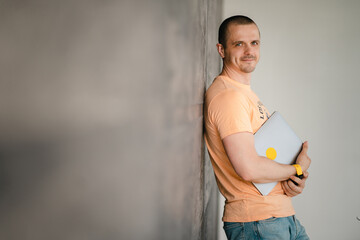 Adult man in yellow t-shirt with laptop