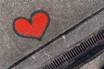 Red graffiti heart with black outline on a street in Berlin, Germany