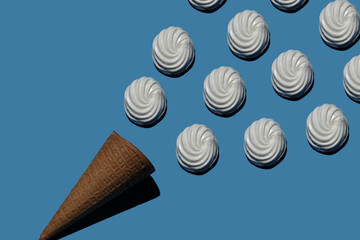 sweet marshmallows and an ice cream cone on a blue background