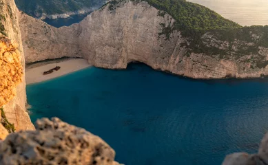 Foto op Plexiglas Navagio Beach, Zakynthos, Griekenland Navagio beach with wreck and flowers at sunset in Zante, Greece. Zakynthos island. Ionian sea, with turquoise sea and white, sandy beach. 