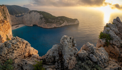 Fototapeta na wymiar Navagio beach with wreck and flowers at sunset in Zante, Greece. Zakynthos island. Ionian sea, with turquoise sea and white, sandy beach. 