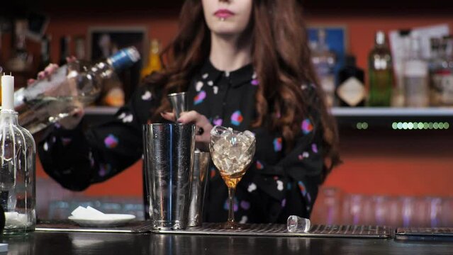 Redhead girl Young adult woman bartender prepares mixes paper airplane cocktail bar Pours ice bells