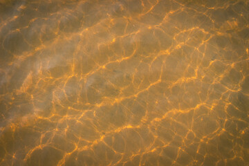 Yellow liquid background. Sunlit sea surface.