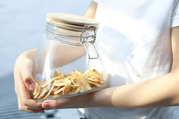 Child holding jar with banana chips close up Dried fruit as healthy snack © Victoriia