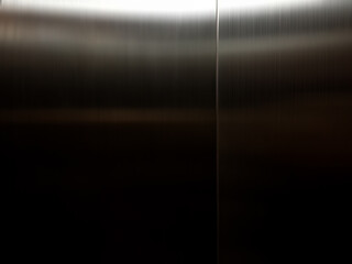 Stainless steel large sheet  With light hitting the surface,Inside passenger elevator,Reflection of light on a shiny metal texture,stainless steel background.