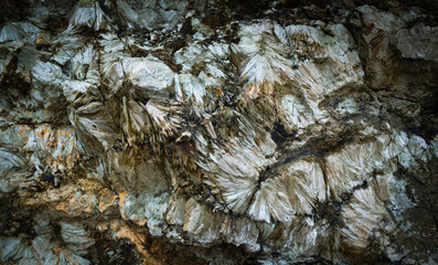 Dark background of natural stone. Detail of a Hedenbergite mineral wall found in Elba island, Italy.