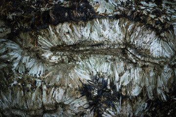 Dark background of natural stone. Detail of a Hedenbergite mineral wall found in Elba island, Italy.