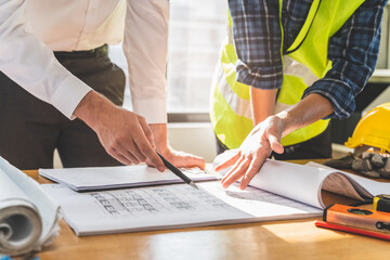 architect explaining client demand plan of construction on the table to contractor.