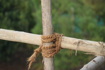 Wooden poles tied up with natural fiber ropes also called scaffolding in the construction term to...