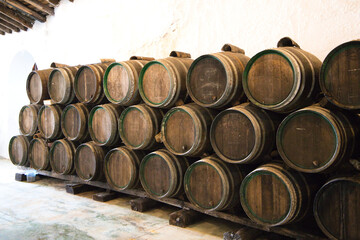 group of wooden barrels from a wine cellar in spain. The barrels are full of wine from the last...