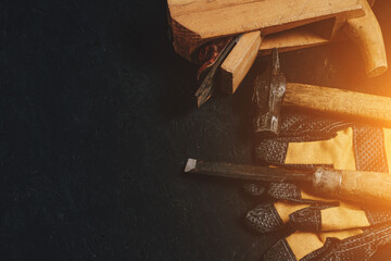Set of tools for carpenters, hammer, chisel and plane with gloves dark wooden background.