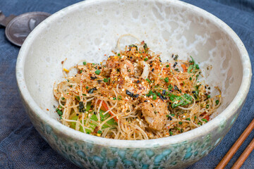 Homemade noodles in Singaporean with shrimps and chicken on bowl