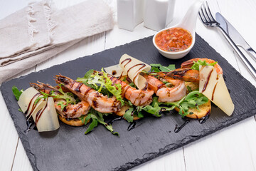 tiger shrimp kebab with greens on black stone