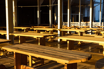 cluster of empty wooden tables in sunlight