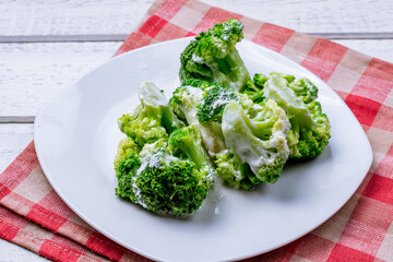 broccoli in garlic sauce on a white plate