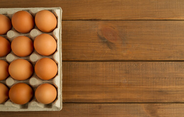 Fresh eggs in pulp carton, cardboard packaging container. Flat lay composition with copy space on wooden panel planks background.