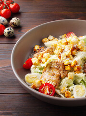Shrimp tail salad grilled chicken, arugula, quail eggs, cherry tomatoes, crackers, olive oil and balsamic vinegar. Top view. Copy space. Close up. Wood background. Lunch, dinner in a cafe, restaurant.