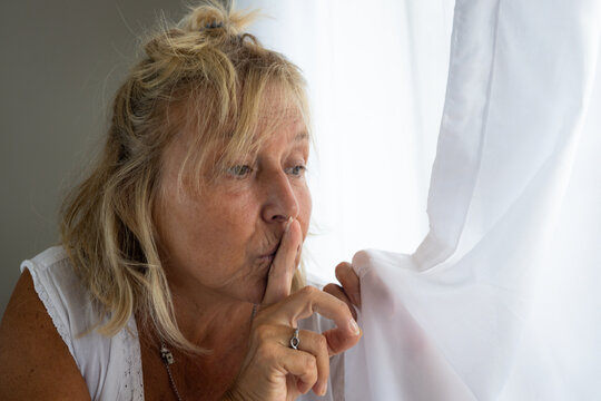 Caucasian Woman From 50 To 60 Years Old With Blond Hair Looking Asking For Silence With Her Hands.