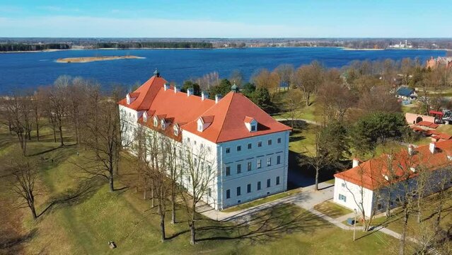 Aerial Shot of Birzai Castle, Fortress Birzai - a Castle in Birzai, on the Southern Coast of the Lake &Scaron;irvėna in Lithuania, Sunny Spring Day. Historic Beautiful Church and Birzai City Panorama 4K UHD 