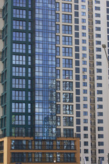 Construction of multi-storey buildings. Modern multi-storey building. Houses built of concrete and glass.