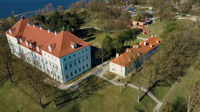 Aerial Shot of Birzai Castle, Fortress Birzai - a Castle in Birzai, on the Southern Coast of the Lake &Scaron;irvėna in Lithuania, Sunny Spring Day. Historic Beautiful Church and Birzai City Panorama 4K UHD 