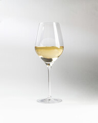 Glass with white wine. On a light background.