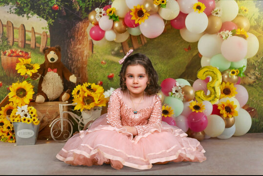 little girl in a pink dress with Masha and the Bear birthday background . happy birthday three years old